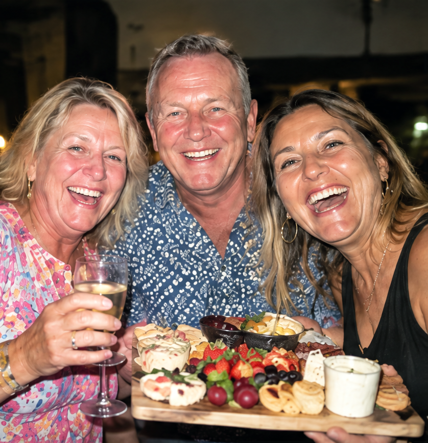 Three guests with a grazing board and champagne